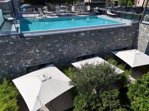 an outdoor pool with umbrellas and a swimming pool at La Giulia Suites like Home in Bonassola