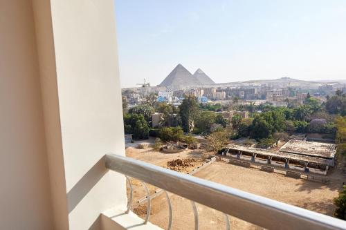 a view of the pyramids from a balcony of a building at Golden pyramids group in Nazlet el-Sîsi