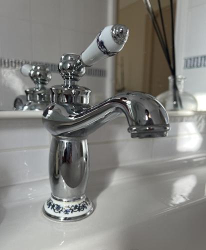 un lavandino del bagno con un rubinetto cromato di Cosy Appartement a Boulogne-Billancourt