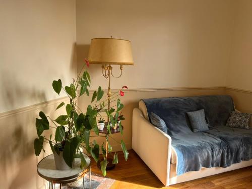 un soggiorno con un divano e una pianta in vaso di Cosy Appartement a Boulogne-Billancourt