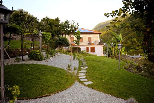 a garden with a house and a lawn at Old Village Linda - Tra Lunigiana & Cinque Terre in Comano