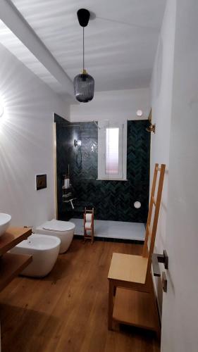 a bathroom with two sinks and a toilet in it at Disìu Apartment con Jacuzzi in centro a Castellammare del Golfo in Scopello