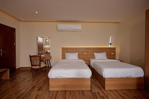a hotel room with two beds and a desk at Golden pyramids group in Nazlet el-Sîsi