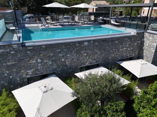 an outdoor swimming pool with umbrellas and a pool at La Giulia Suites like Home in Bonassola