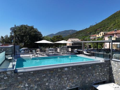 a swimming pool with chairs and umbrellas on a building at La Giulia Suites like Home in Bonassola