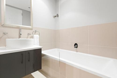 a bathroom with a sink and a bath tub at Eden on the Bay 190 by Host Agents in Cape Town