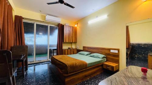 a bedroom with a bed and a large window at Beach at Deltin in Udupi
