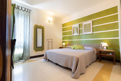 a bedroom with a bed with green and white stripes at Hotel Al Convento in Vezzano Ligure