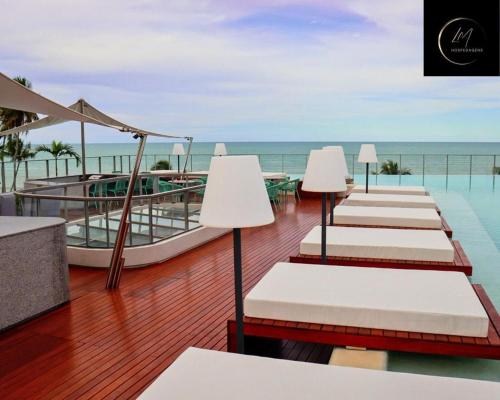 a row of chaise lounges on a deck with the ocean at LM Setai Yacht Cabo Branco in Tambaú