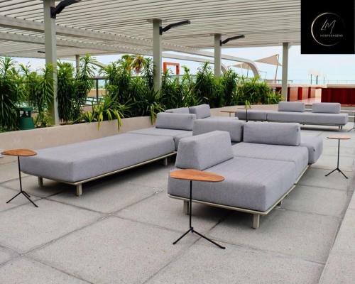 a row of couches in a building with tables at LM Setai Yacht Cabo Branco in Tambaú