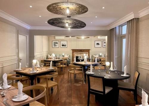 a restaurant with tables and chairs and a fireplace at 10 2nd Avenue Houghton Estate by Dream Resorts in Johannesburg