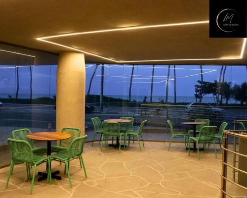 a restaurant with tables and chairs and a view of the ocean at LM Setai Yacht Cabo Branco in Tambaú