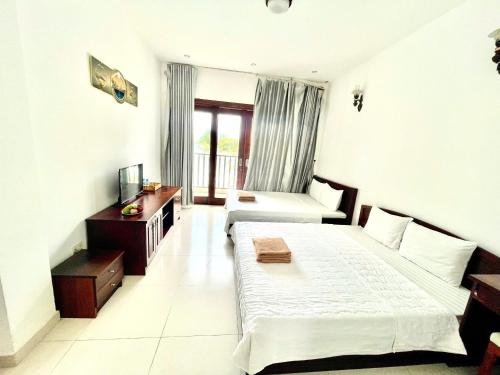a hotel room with two beds and a television at Resort HAVANA in Mui Ne
