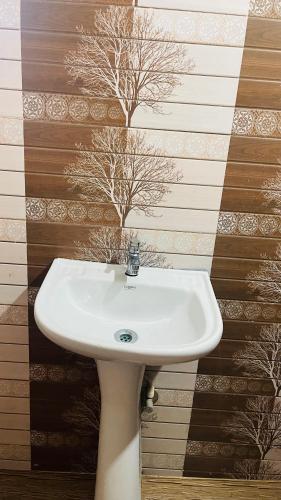 a white sink in a bathroom with a wall at Beach at Deltin in Udupi