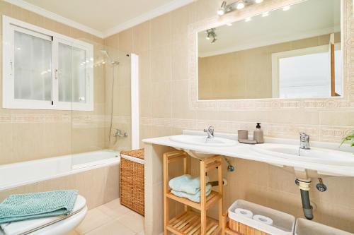 a bathroom with a sink and a toilet and a mirror at Casa Bahía Azul in La Herradura