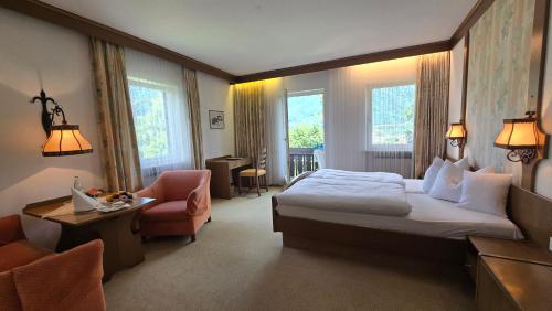 a hotel room with a bed and a chair at Hotel Alpina in Bad Reichenhall