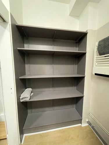 a walk in closet with gray shelves in a room at La clé de Fa 4 meublé cosy au coeur de la cité Vauban in Gravelines