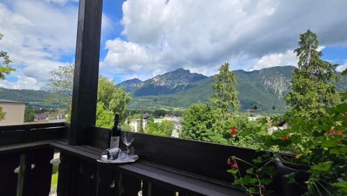 a glass of wine on a balcony with mountains at Hotel Alpina in Bad Reichenhall