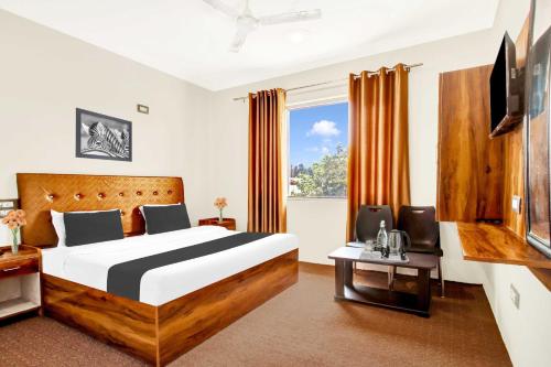 a bedroom with a large bed and a large window at Hotel O Dal Lake in Srinagar