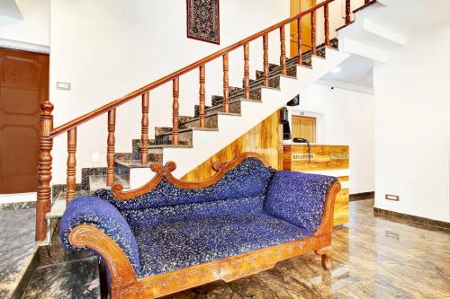 a blue couch in a living room with stairs at Hotel O Dal Lake in Srinagar