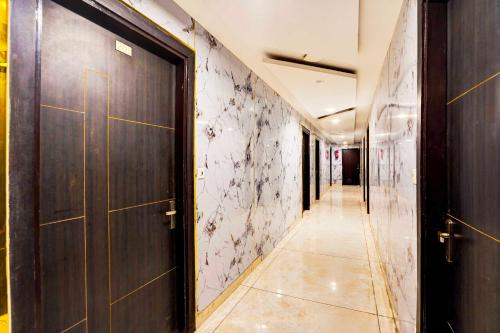 a corridor with a door in a building with a tile floor at Hotel O Surya Enclave Aroma Regency in Meerut