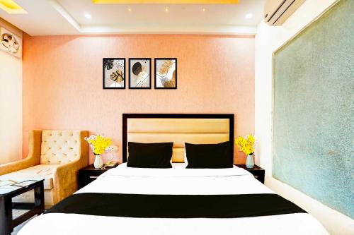a bedroom with a bed and two tables and a couch at Hotel O Surya Enclave Aroma Regency in Meerut