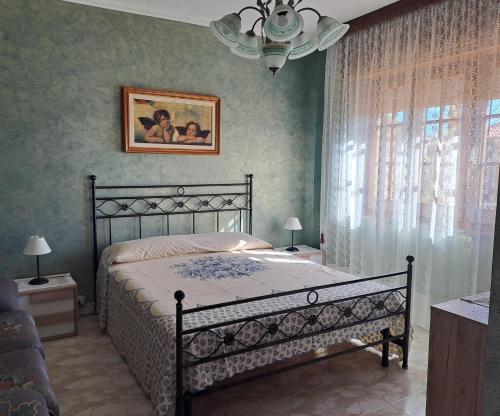 a bedroom with a bed and a chandelier at Casa da Luisa in Domusnovas