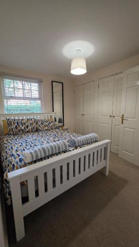 a large white bed in a room with a window at Shrubbery - Balcony Apartment in High Wycombe