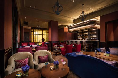 a restaurant with red chairs and tables and a bar at The Pury Hotel in Yiwu