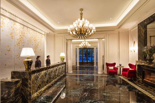 a lobby with a chandelier and red chairs at The Pury Hotel in Yiwu
