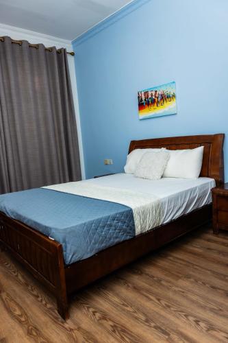 a bedroom with a bed in a blue room at Eastern Hills Apartments in Accra