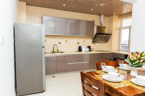 a kitchen with a table and a refrigerator at Eastern Hills Apartments in Accra