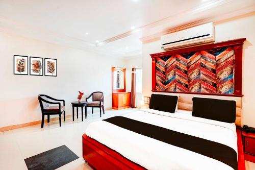a bedroom with a bed and a table and chairs at Collection O Anantapur Near Srikantam Circle in Anantapur