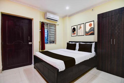 a bedroom with a large bed with a black door at Hotel O Zoological Park Nandankanan Resort in Bārang