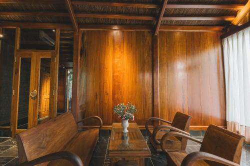 a dining room with wooden walls and a table and chairs at Tam Coc Golden Fields Retreat in Vũ Lâm