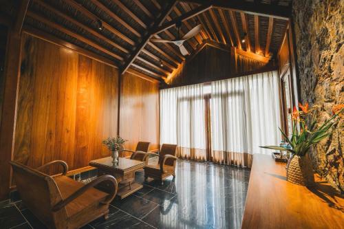 a lobby with chairs and a table and a window at Tam Coc Golden Fields Retreat in Vũ Lâm