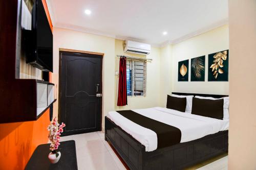 a bedroom with a bed with a black door and a tv at Hotel O Zoological Park Nandankanan Resort in Bārang