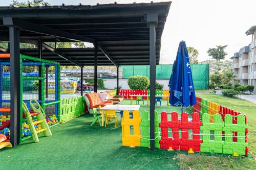 a play area with a table and an umbrella at Senza Sunset Beach Hotel in Alanya