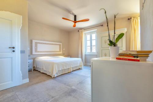 a bedroom with a bed and a ceiling fan at Dimora Sella - Casa Monica in Alghero