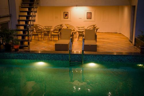 a swimming pool with a table and chairs next to a table and a dining room at Hotel Tapovan Hills in Rishīkesh