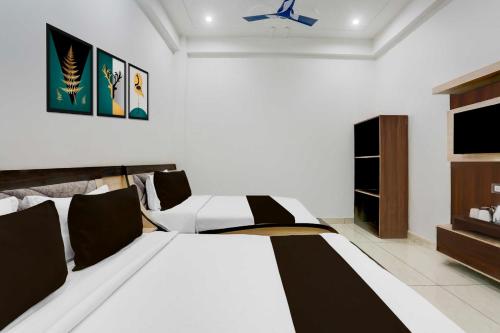 KhātuにあるCollection O Khatu Shyam formally hotel Dev Bhumiの白いベッドとテレビのある寝室