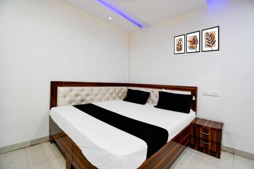 a bedroom with a white bed with black pillows at Collection O Gorakhpur Industrial Area Shaurya Inn in Pipra