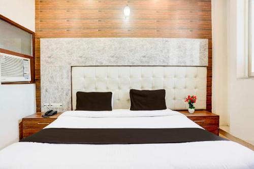 a bedroom with a large white bed and wooden walls at Collection O Chandigarh Highway Near Prabhat Road in Chandīgarh