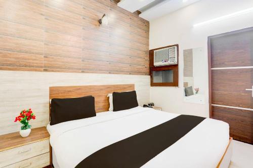 a bedroom with a white bed and a wooden wall at Collection O Chandigarh Highway Near Prabhat Road in Chandīgarh