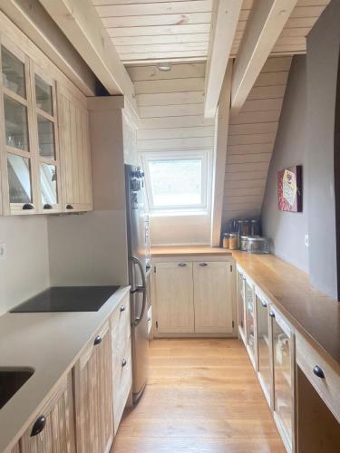 a large kitchen with wooden cabinets and a window at Magnifico duplex en centro Viella in Vielha