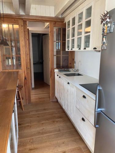 a kitchen with white cabinets and a stainless steel refrigerator at Magnifico duplex en centro Viella in Vielha