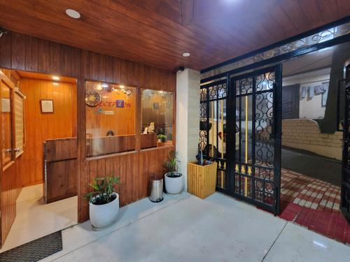 a store front with a door with potted plants at Florence B&B Near Mall Road - Amazing Valley View in Shimla