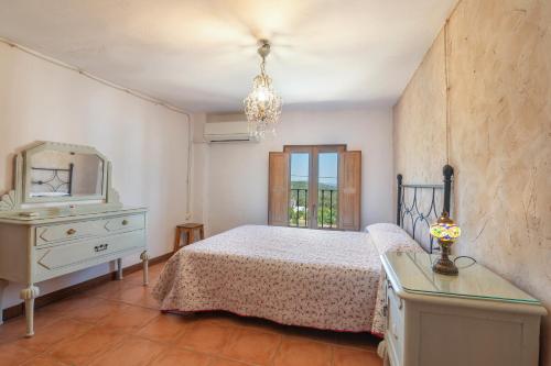 a bedroom with a bed and a dresser and a mirror at Casa Rural La Trastienda in Almonaster la Real