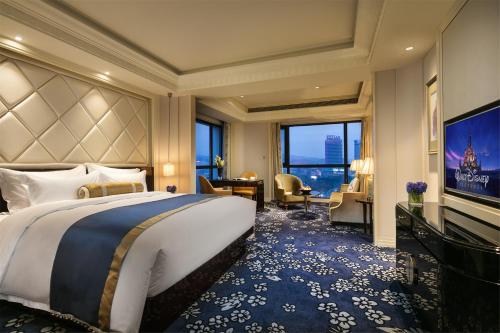 a bedroom with a large bed and a large window at The Pury Hotel in Yiwu