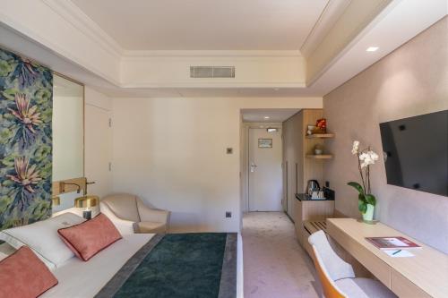 a hotel room with a bed and a tv at Rodos Park in Rhodes Town